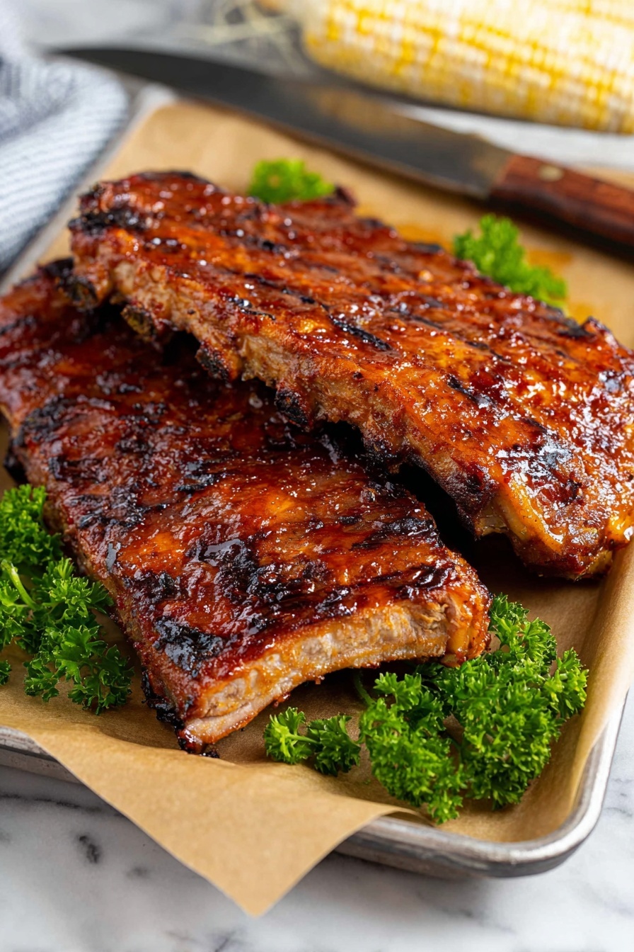 Two thick racks of grilled ribs with a shiny, sticky glaze rest stacked on top of each other on a baking tray lined with light brown parchment paper. The ribs have clear dark grill marks and a mix of reddish-brown caramelized surface with slight charring. Behind the ribs, bright green leafy parsley provides a fresh pop of color. The tray sits on a white marbled surface next to a large knife with a dark handle and a white corn cob in the background. photo taken with an iphone --ar 2:3 --v 7