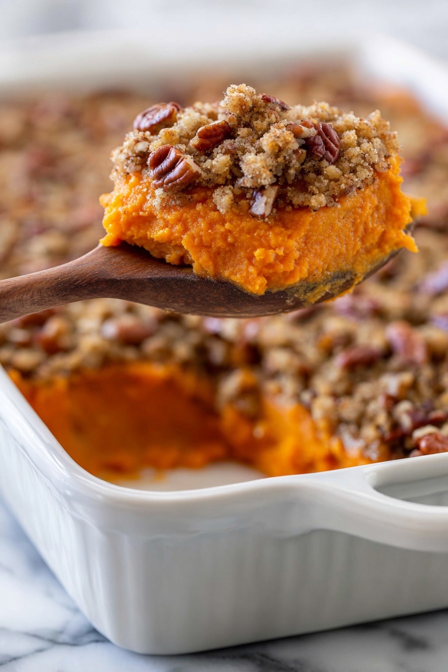The dish shows a close-up of a piece of orange sweet potato mash topped with a crumbly, light brown pecan streusel with visible pecan pieces, lifted by a wooden spoon above a white ceramic baking dish filled with the same layered dessert. The sweet potato layer is smooth and dense at the bottom, while the topping is crunchy and textured, sitting evenly on top. The background is a white marbled surface. Photo taken with an iphone --ar 2:3 --v 7