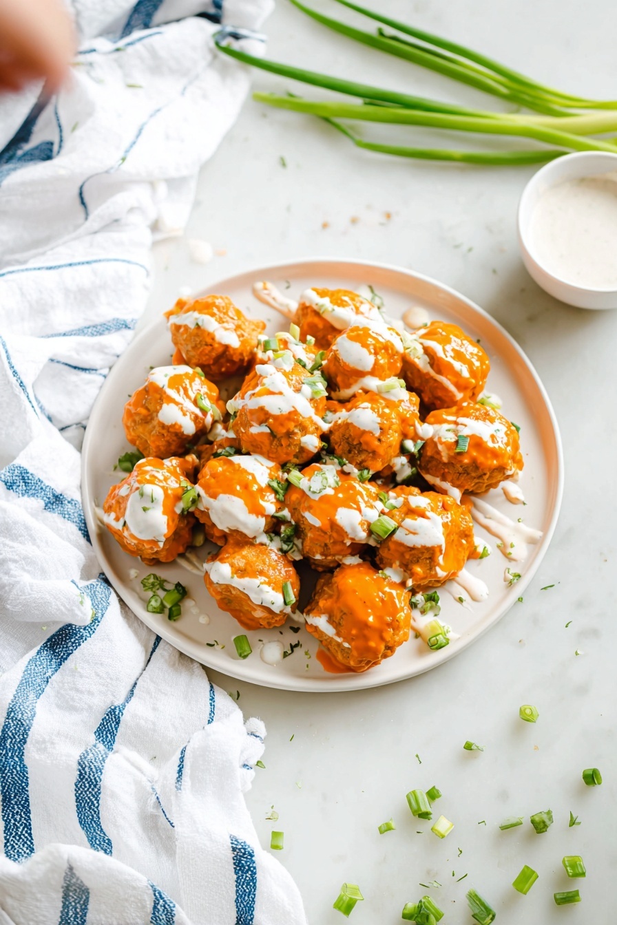 A white plate filled with about fifteen round orange-brown balls covered in a thick, bright orange sauce. Each ball has a drizzle of white creamy sauce on top, with small green onion pieces scattered across the dish for garnish. A woman's hand is holding a silver fork that is picking up one ball, showing its moist texture under the sauce. The plate sits on a white marbled surface with a blurred white bowl in the background. photo taken with an iphone --ar 2:3 --v 7