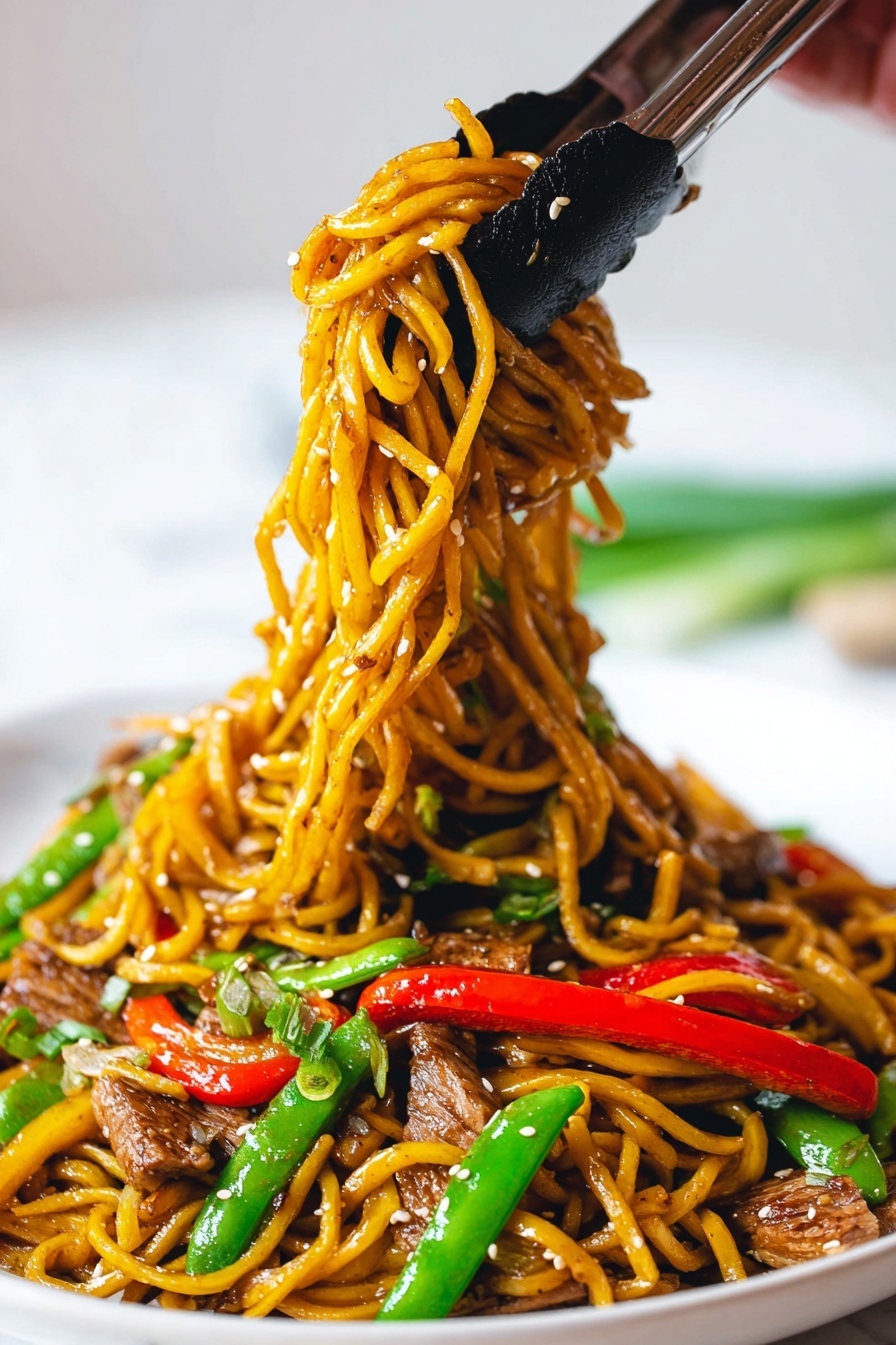 The image shows a close-up of a served plate filled with yellow-brown stir-fried noodles mixed with bright green snap peas, red bell pepper strips, and pieces of cooked meat that are light brown with grill marks. The noodles glisten with sauce and are sprinkled with white sesame seeds. A pair of black-tipped tongs is lifting a bundle of the noodles along with vegetables, held by a woman's hand. The plate is white and sits on a white marbled surface, with some green onion segments blurred in the background. The colors are vivid and the textures show the softness of the noodles and the crunch of the vegetables. photo taken with an iphone --ar 2:3 --v 7