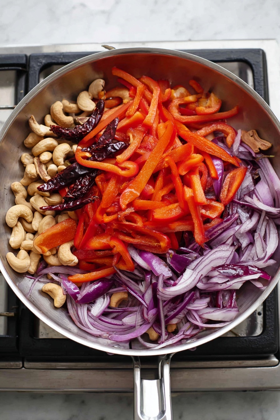 A white bowl holds a colorful dish with three main layers: on the right side, a layer of plain white rice with separated grains; the rest of the bowl is filled with a mix of dark brown glazed chicken pieces that have a shiny and slightly sticky texture, bright red sliced bell peppers scattered throughout, whole golden-brown cashew nuts, and dried red chili peppers on top. The dish is garnished with small green herb pieces sprinkled over the food. Black chopsticks rest on the right side of the bowl against the food, all set on a white marbled surface with some dried chilies scattered nearby. Photo taken with an iphone --ar 2:3 --v 7